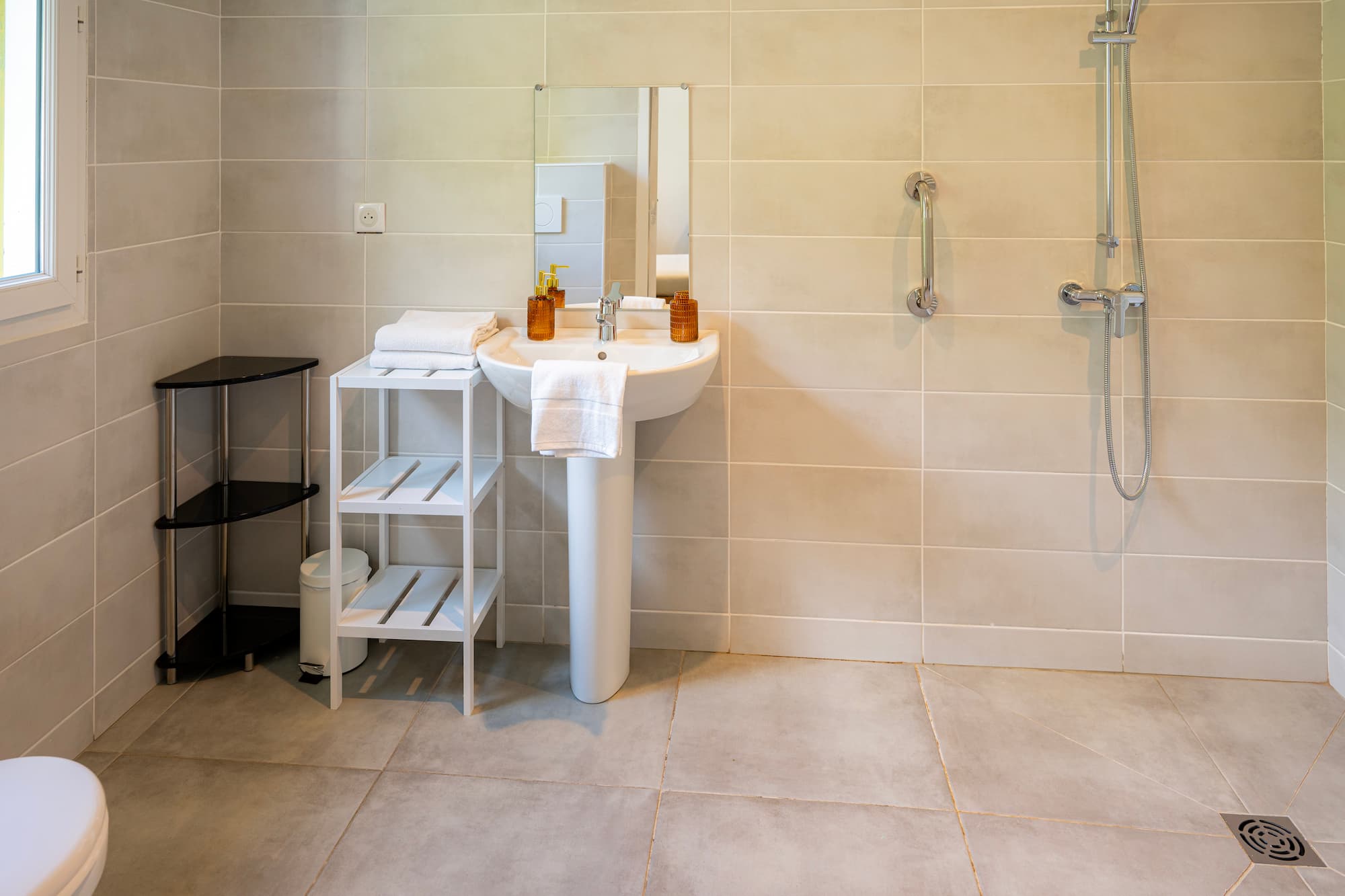 Jolie salle de bain récente avec carrelage gris et douche à l'italienne